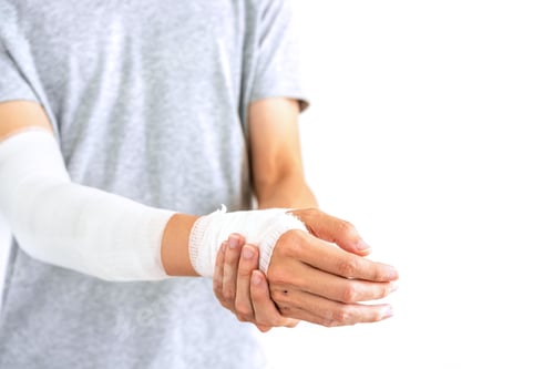 Preview: Young man with gauze bandage wrapped around injury hand on white background