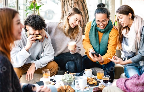 Preview: Multicultural friends playing with mobile phone at coffee bar