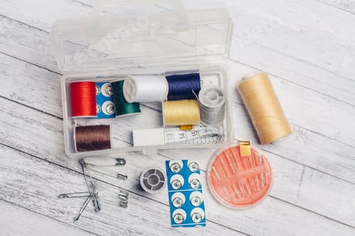 Preview: thread needles sewing supplies in a plastic box on a wooden background