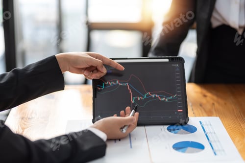 Preview: Investor team analyzes the stock market on a tablet at the meeting.