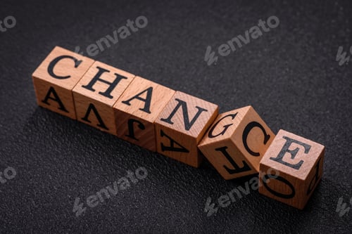Preview: The inscription chance or change with wooden cubes on a dark concrete background