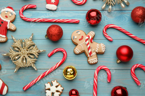 Preview: Flat lay composition with tasty candy canes and Christmas decor on light blue wooden table