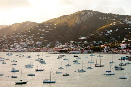Sailboats Moored near Town by Lush Green Hills