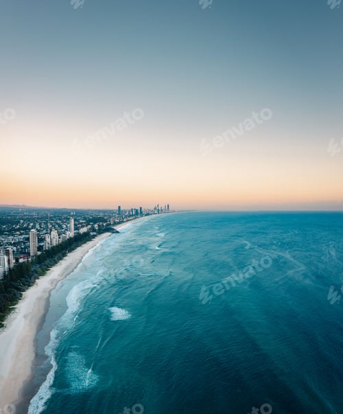 Preview: Aerial shot of a long sandy coastline with residential houses and tall buildings in Burleigh Heads