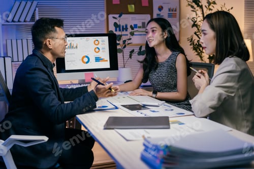 Preview: Business team analyzing financial data on computer screen, discussing company performance and growth
