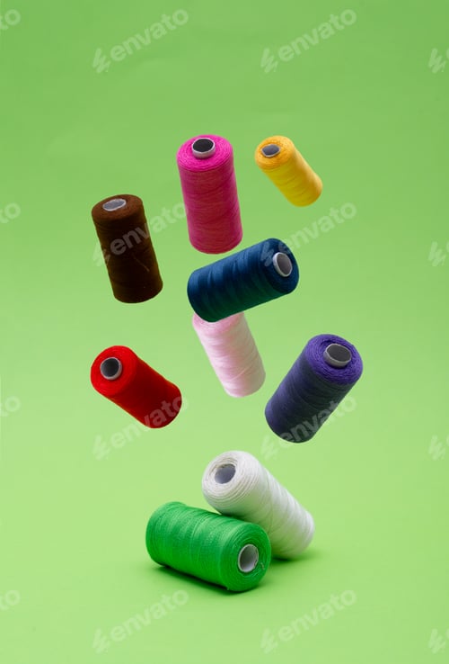 Preview: Various spools of sewing cotton thread of different colors floating.