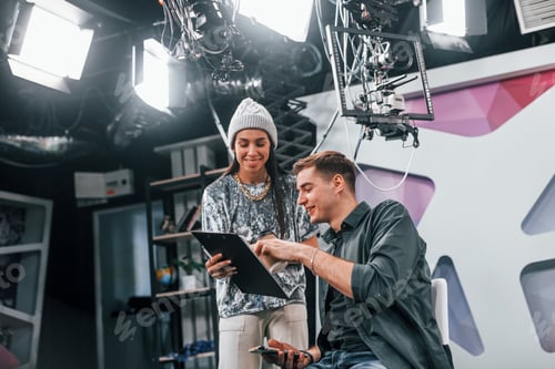 Preview: Young man is preparing for TV online broadcast. Woman helps with make up