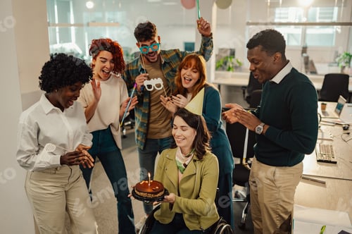 Preview: Birthday girl who uses a wheelchair holding a cake and celebrating in the office