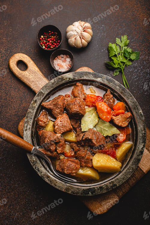Preview: Meat beef stew with vegetables and gravy in rustic metal pot top view