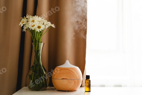Preview: Aromatherapy concept. Aroma oil diffuser on the table against the window.