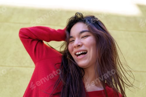Preview: Cheerful Japanese woman in red sweater, playfully tossing hair and laughing