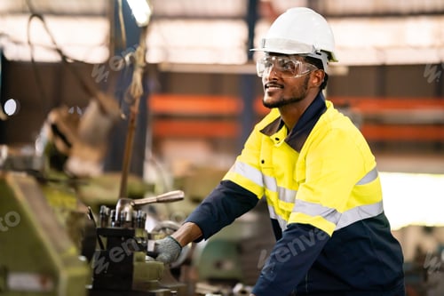 Preview: Production engineers in safety wear are assisting adjusting and maintaining CNC or factory machine