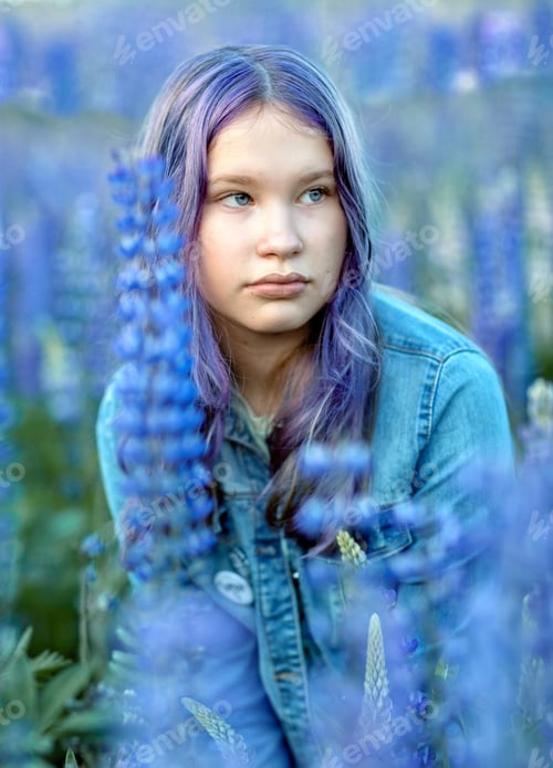 Visualização: Teenage girl in blue lupine flowers. Beautiful blue background.