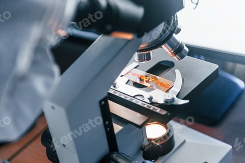 Preview: Close up view of scientist in protective uniform that works with coronavirus in laboratory