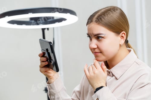 Preview: Makeup artist applies eyebrow tint for the permanent makeup of a young girl. Professional make-up