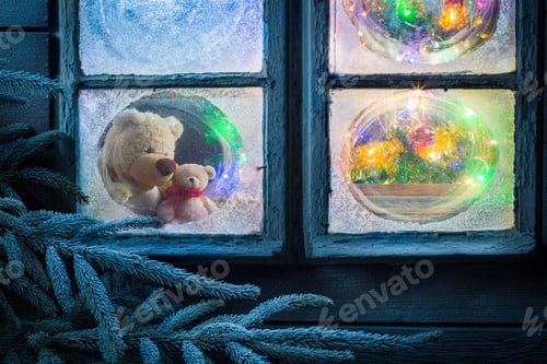 Preview: Teddy bear and light on tree for Christmas in frozen window