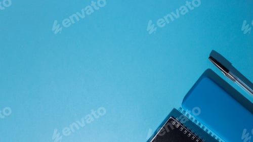 Preview: Top view of a smartphone and a notepad with a pen on a blue background