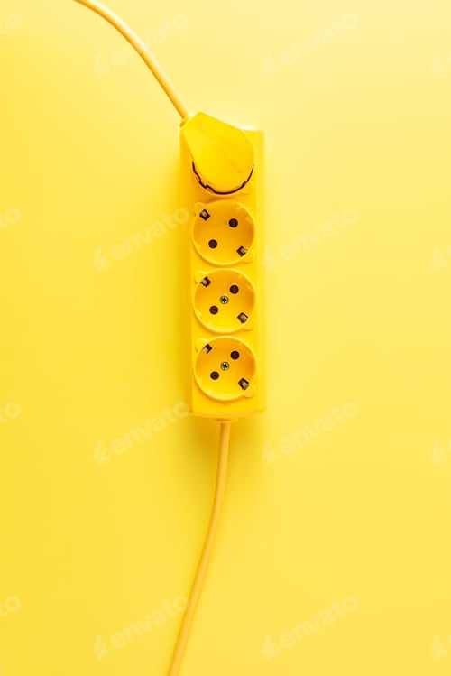 Preview: top view of bright yellow socket outlet with plug on yellow background