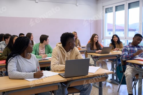 Preview: Multiethnic students studying together in modern classroom