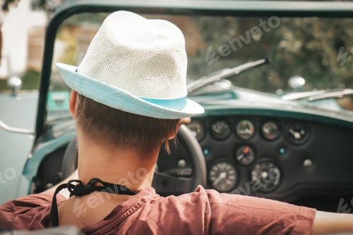 Preview: Woman from behind driving a retro car