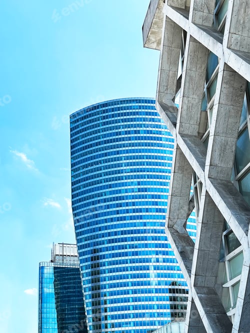 Preview: View To Tops Of Glass Modern Geometric Architecture Buildings on Blue Cloudy Sky Background
