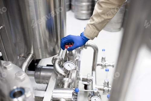 Preview: a male worker on the factory repair the pipe and hose joint, drink production equipment