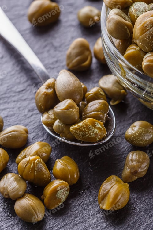 Preview: pickled capers on a dark stone background