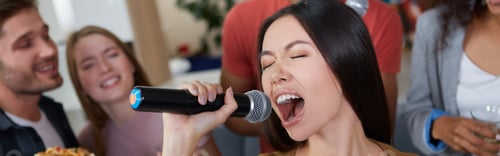 Preview: Karaoke party. Beautiful young asian girl holding microphone and singing while playing karaoke with