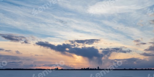 Preview: Clouds in sunset sky over panoramic city silhouette.