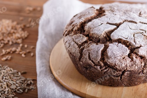 Preview: Yeast free homemade bread with whole rye and wheat grains on rustic wooden background.