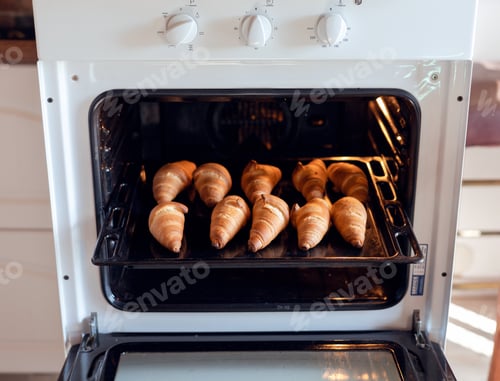 Preview: Oven-baked croissants on baking sheet. Sweet bagels baked in hot oven.