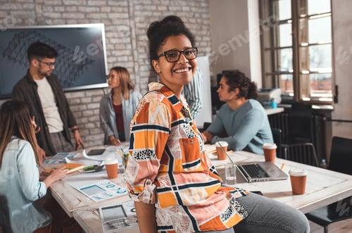 Preview: Portrait of young female leader standing in office looking at camera.