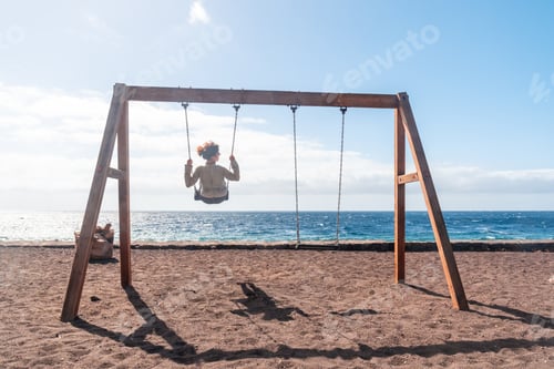 Preview: A woman on vacation swinging on a swing on the beach of the island of El Hierro. Canary Islands