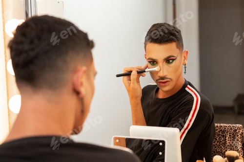 Preview: young drag queen artist doing her makeup in the dressing room