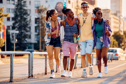 Preview: Multiracial group of cheerful friends going to summer music festival.
