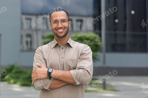Preview: Portrait of young hispanic student man smiling and looking at camera near university campus with
