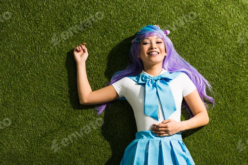 Preview: Smiling asian anime girl in purple wig lying on green grass