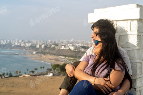 Preview: Young couple embracing admiring city and ocean view