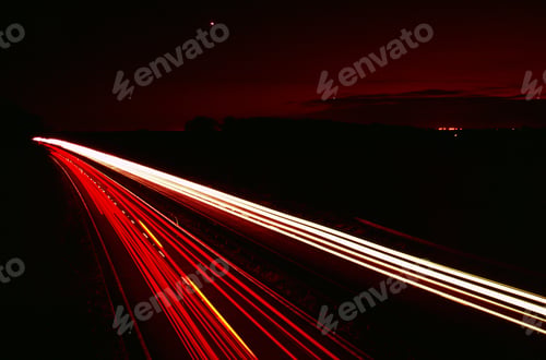 Preview: Red light trails at night. Red and white lines on dark background.
