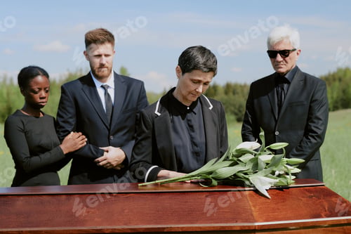 Preview: Middle Aged Caucasian Woman Mourning Beside Coffin with Diverse Mourners