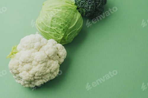 Preview: Healthy fresh broccoli, cabbage and cauliflower on green background