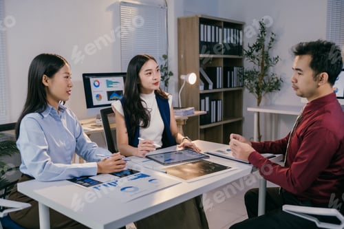Preview: Business team discussing and brainstorming, analyzing sales data chart using tablet and computer in