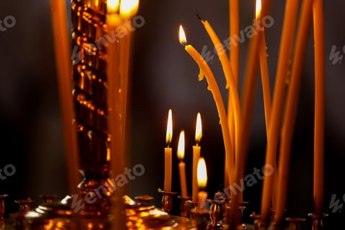 Preview: last candle burn in an Orthodox church. Church candle burn on a large gold candlestick in the