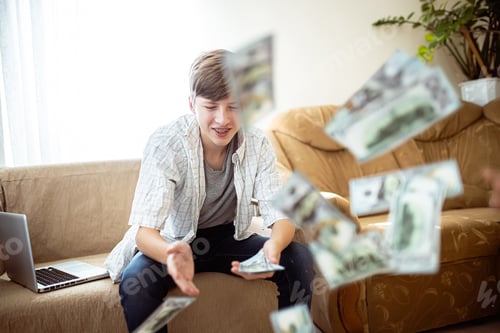 Preview: The teenager wastes money. Boy happily scatters banknotes
