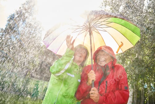 Preview: Happy couple standing with umbrella