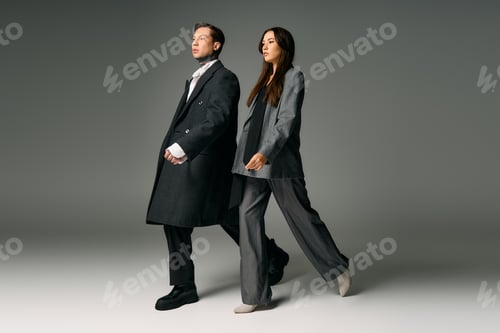 Preview: Young and stylish couple walking confidently in modern fashion during a studio shoot