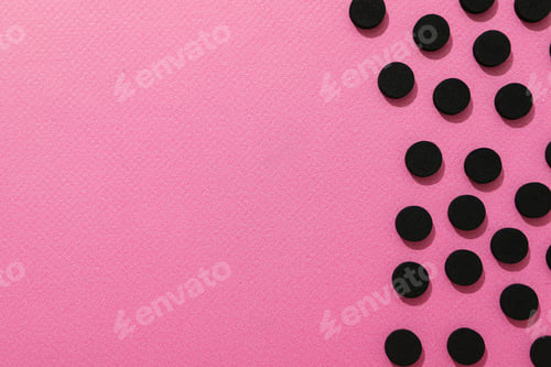 Preview: Activated charcoal tablets on a pink background