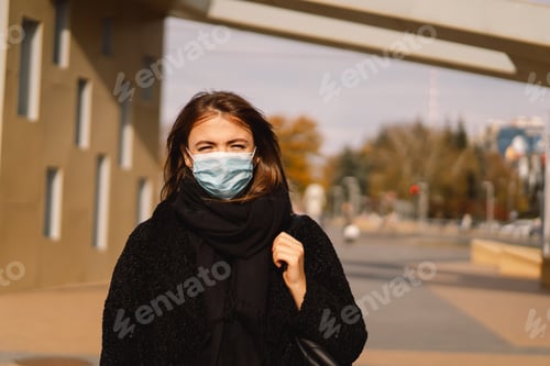 Preview: A woman in a medical protective mask walks down the street in the city.