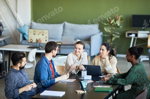 Preview: Young colleagues listening to confident businessman explaining his viewpoint