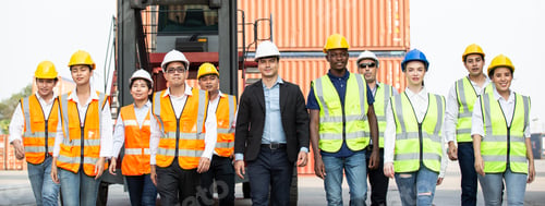 Preview: Corporate logistic team walking together at container warehouse